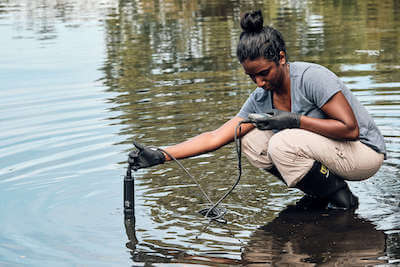 Swathi Manivannan using a water sampling probe at MLK Park, Orlando, FL. Research being conducted for Andrea Ayala's project In Hot Water - Waterfowl, Climate Change, and Vibriosis. Credit: Allaire Bartel